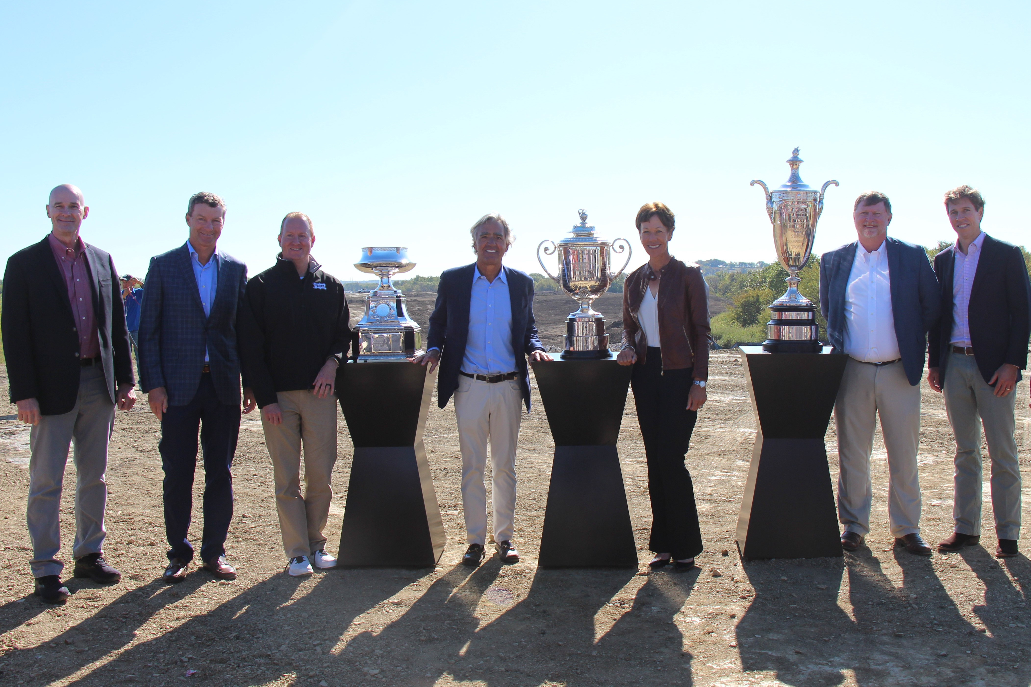 PGA of America executives and City of Frisco representatives gather for a photo with three large PGA trophies at the PGA of America golf course ground breaking ceremony.