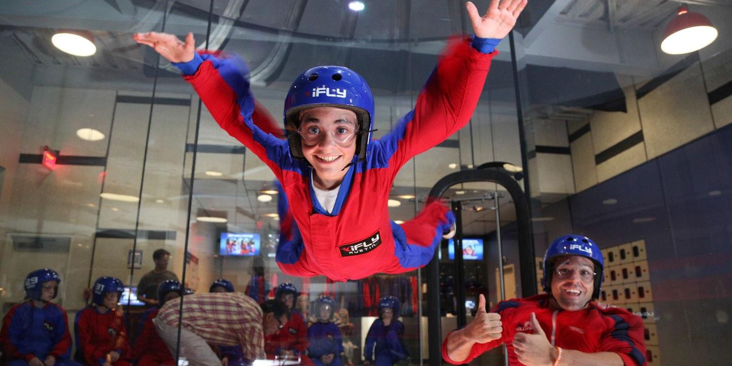 A child smiles as they experience iFly.