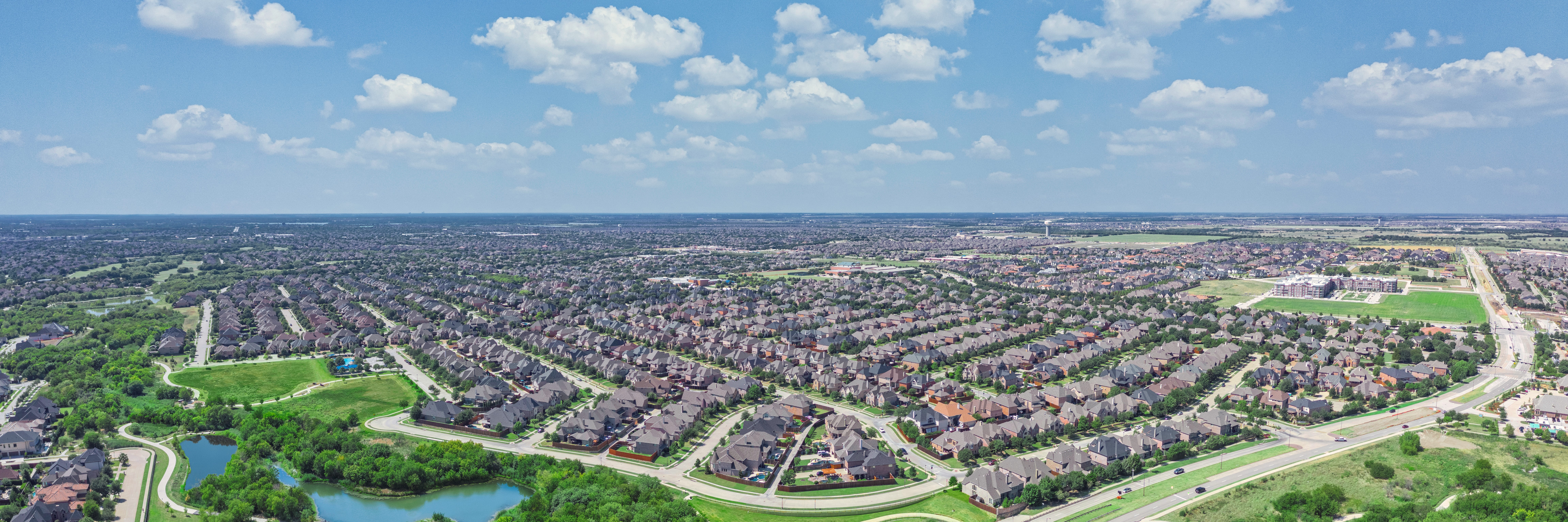Aerial image with a large residential neighborhood and a park with walking trails.