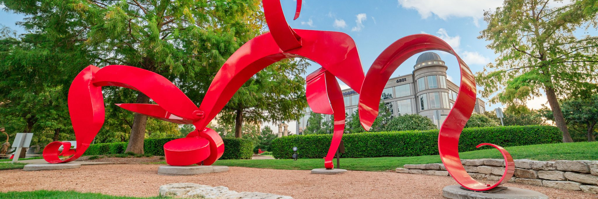 A red, winding statue at the Texas Sculpture Garden.