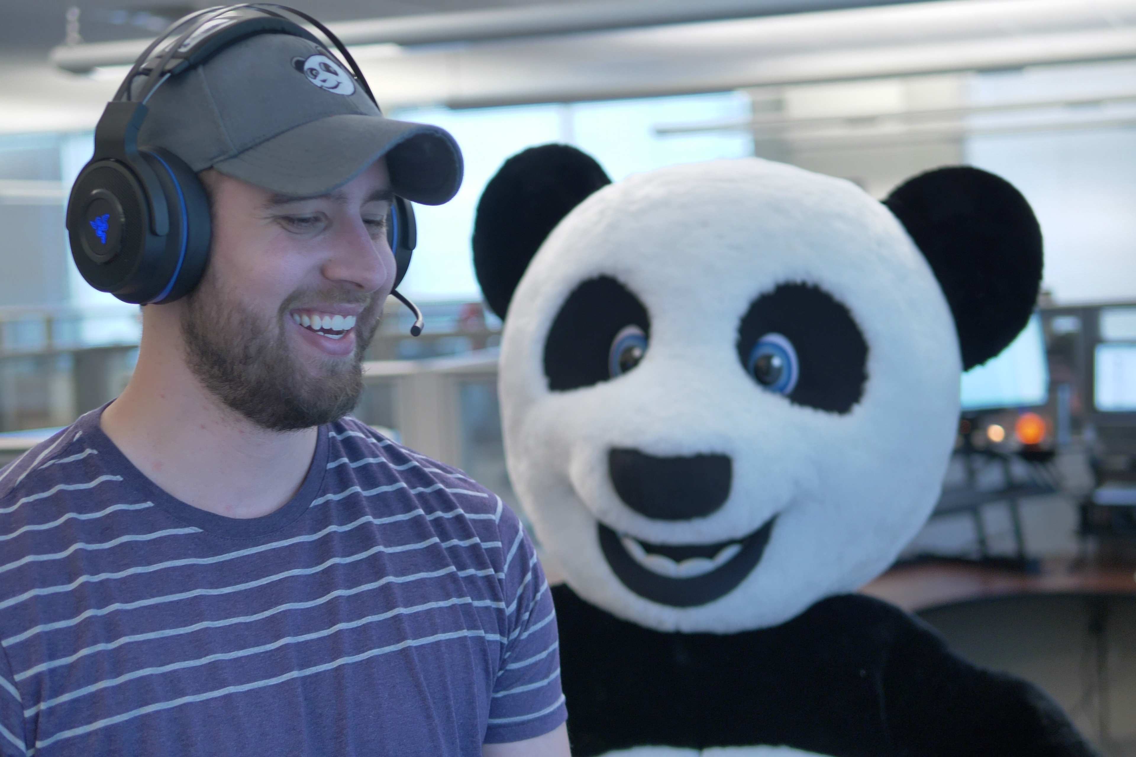 An Asset Panda employee wearing a headset is accompanied by a person in a panda costume.