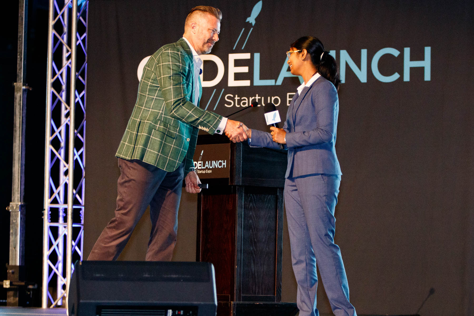 A woman is congratulated on stage for an award at Code Launch.