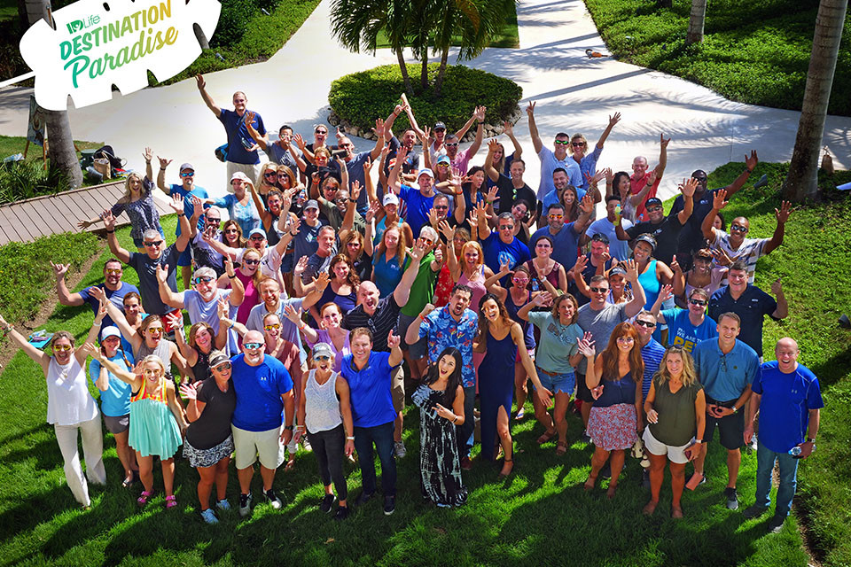 ID Life employees gather for a large group photo outside.