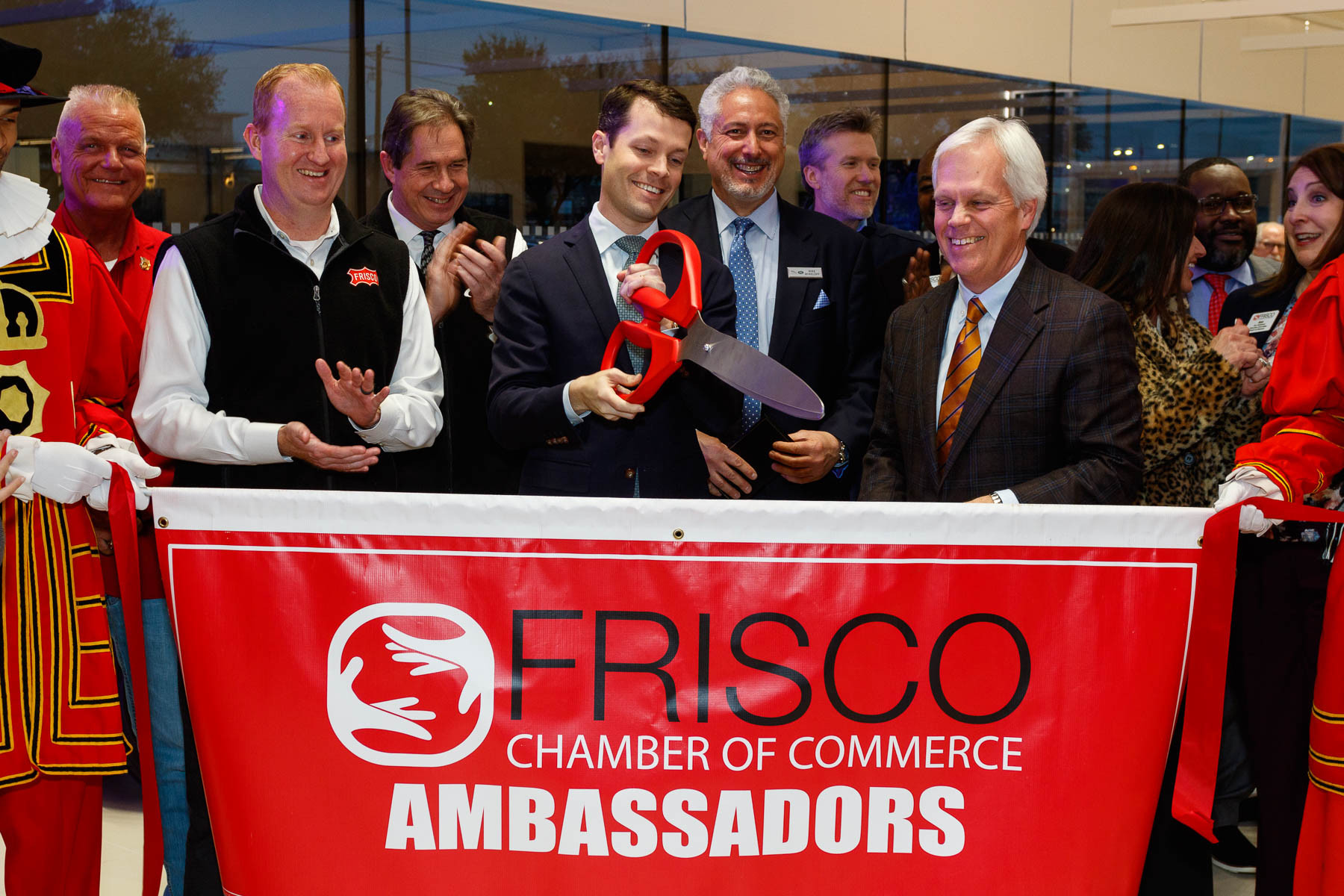 People gather for a picture at a ribbon-cutting ceremony.