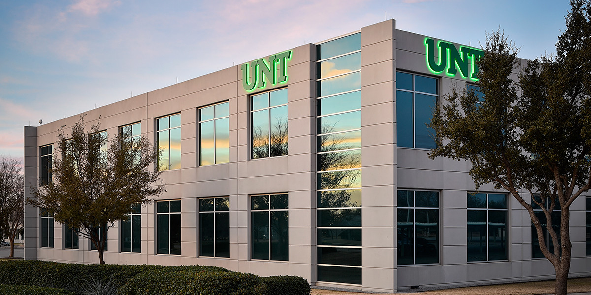 Two-story building with the green University of North Texas logo.
