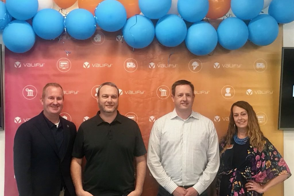 City of Frisco and Valify representatives pose for a photo in front of a background.